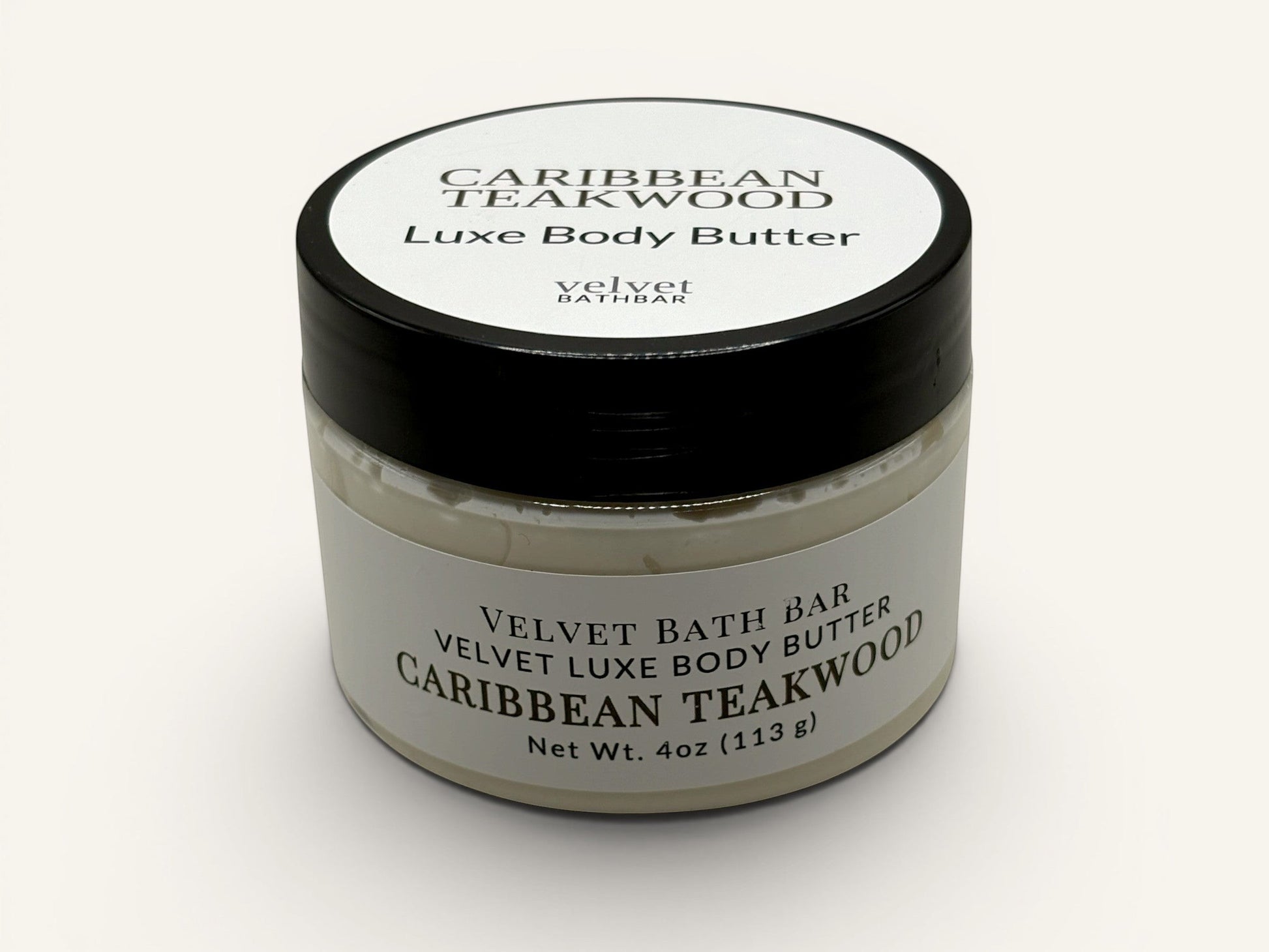 Velvet Bath Bar Caribbean Teakwood Luxe Body Butter in a clear jar with a black lid. Net Wt. 4oz.