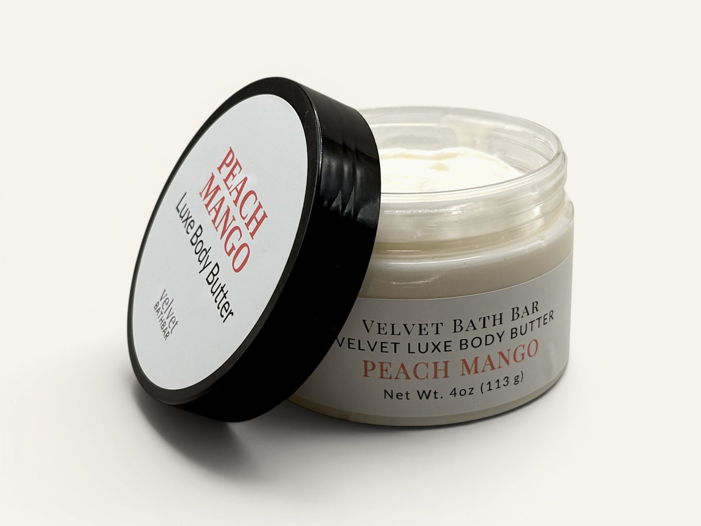 Velvet Bath Bar Peach Mango Luxe Body Butter in a clear jar with a black lid. Creamy white body butter.